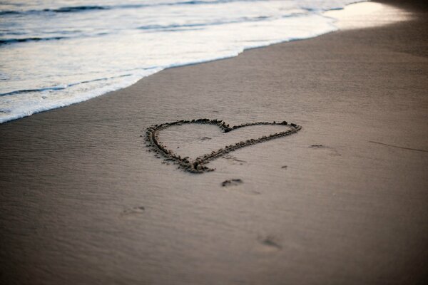 Photo de coeur sur le sable sur la mer