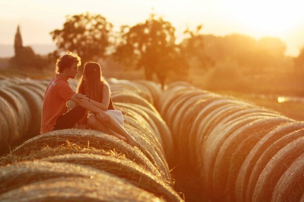 Couple on a haystack at sunset