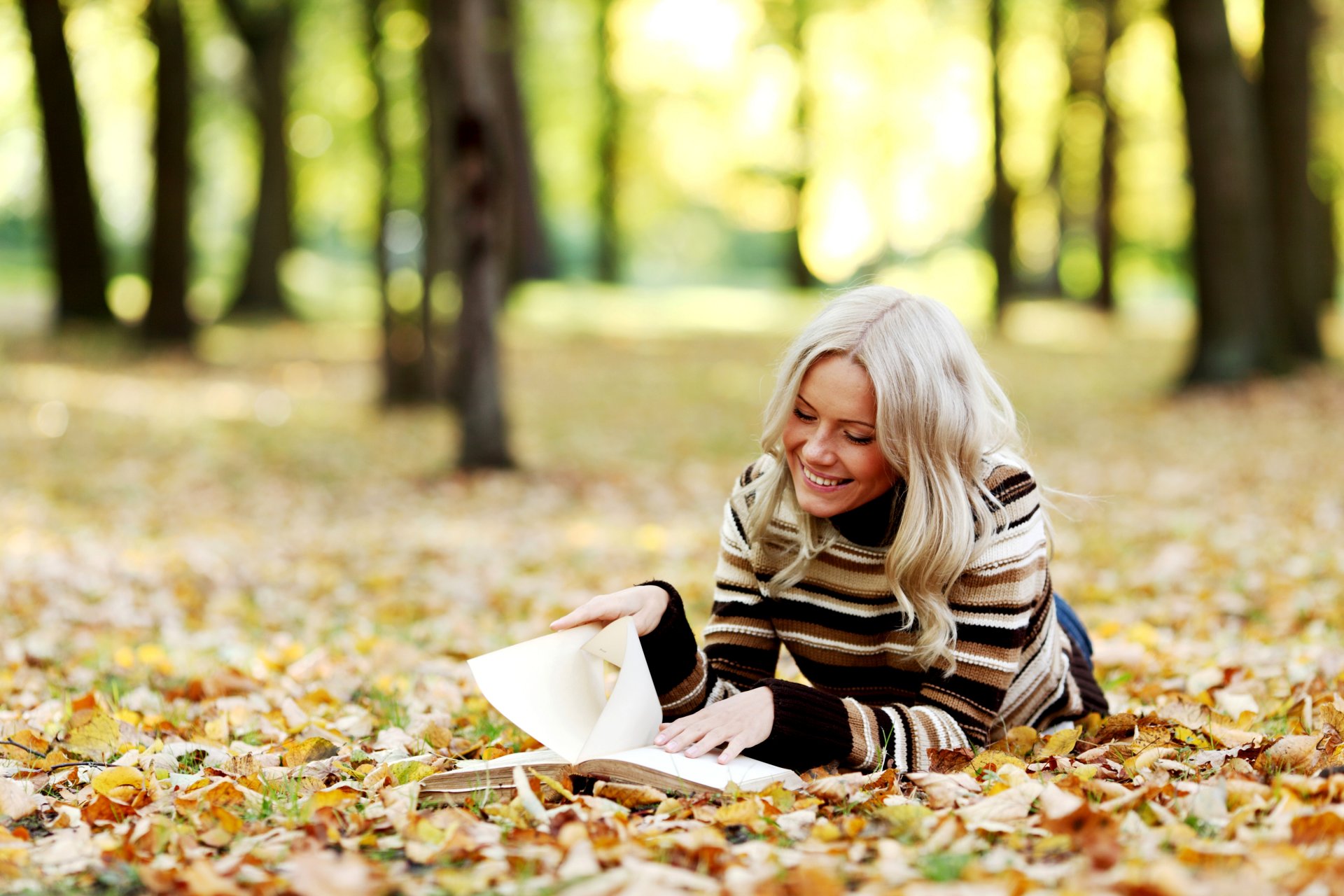 girl blonde reads book smile autumn leaves tree