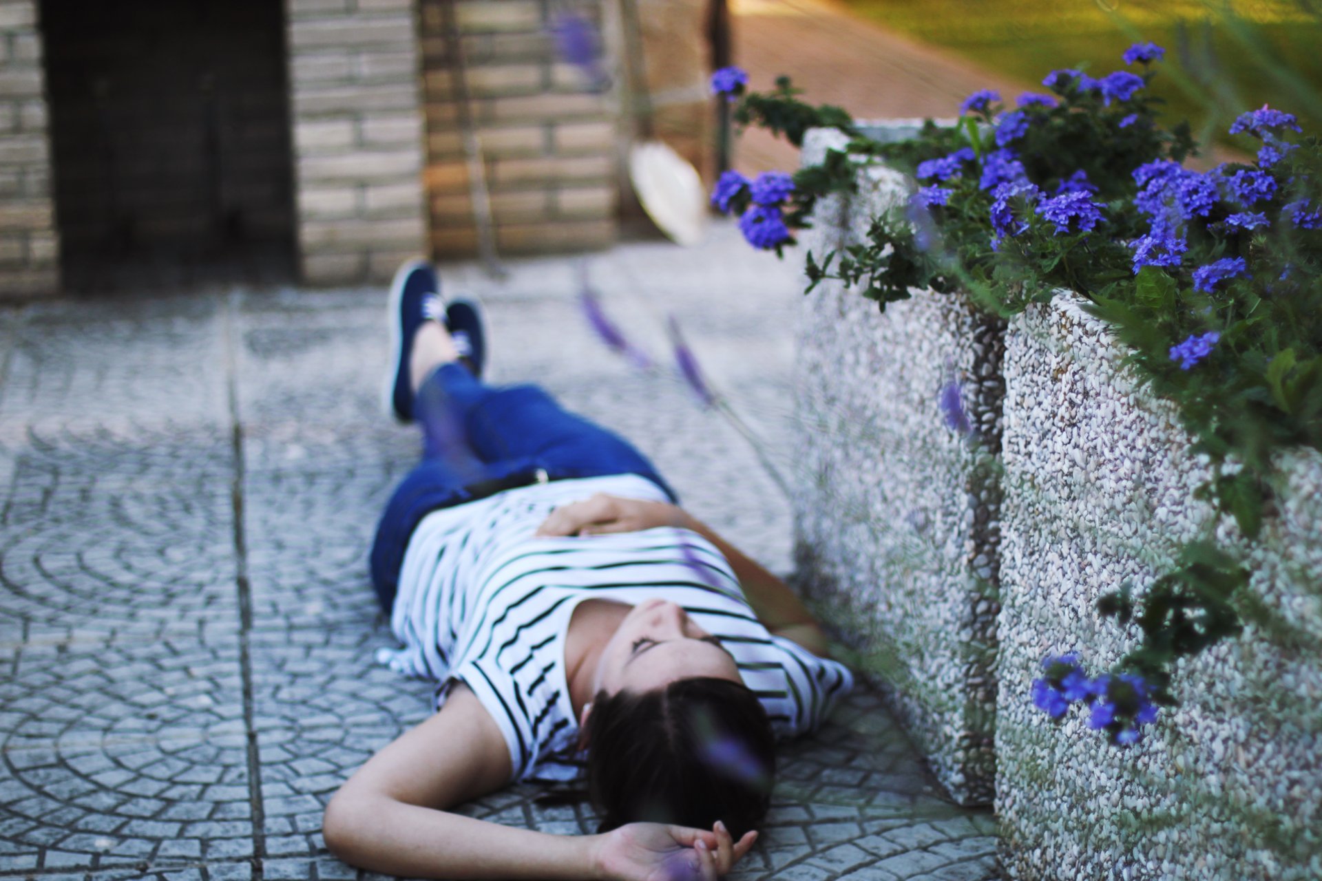 umore ragazza bruna si trova asfalto fiori fiori. natura sfondo carta da parati