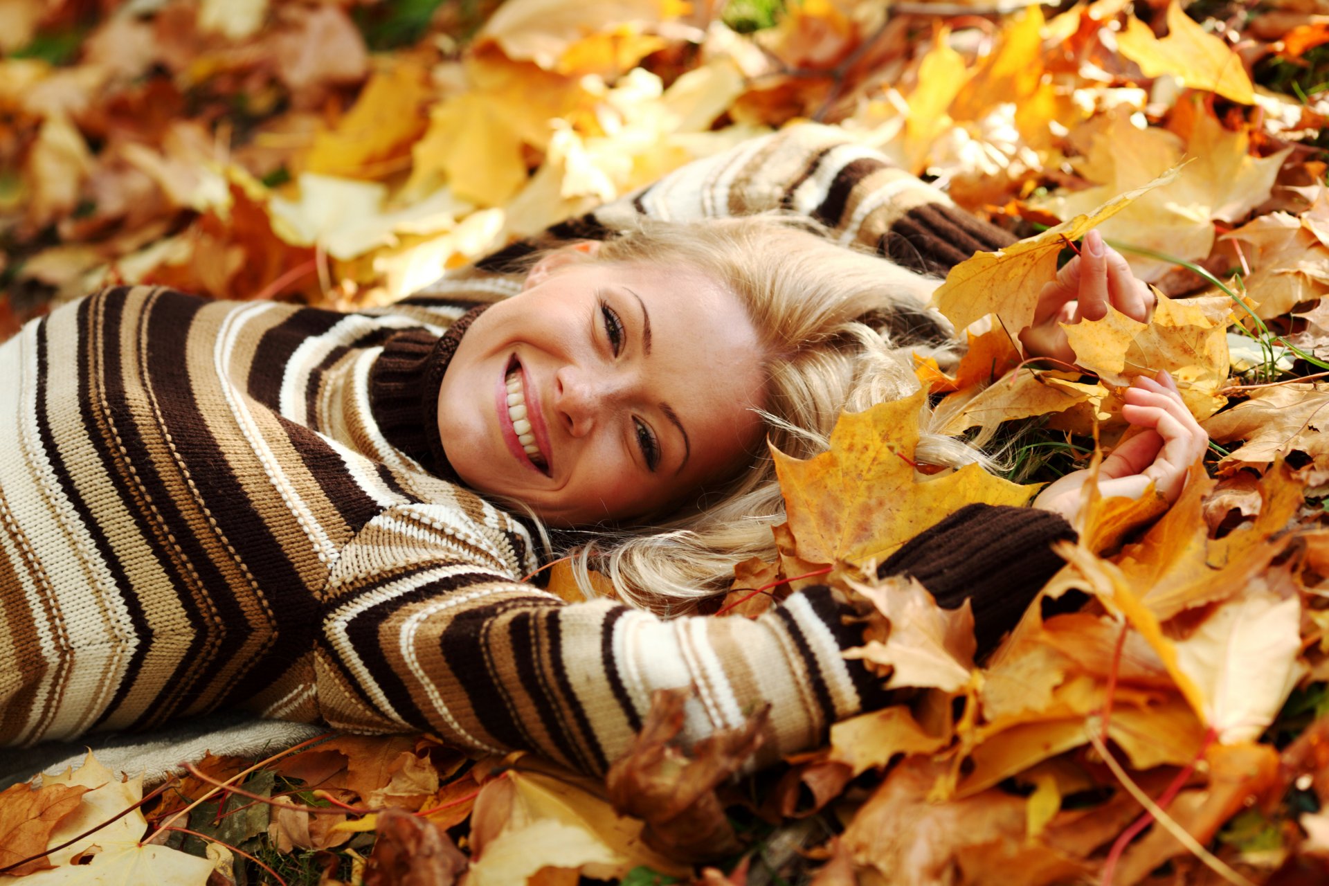 ragazza bionda maglione sorriso si trova autunno foglie giallo