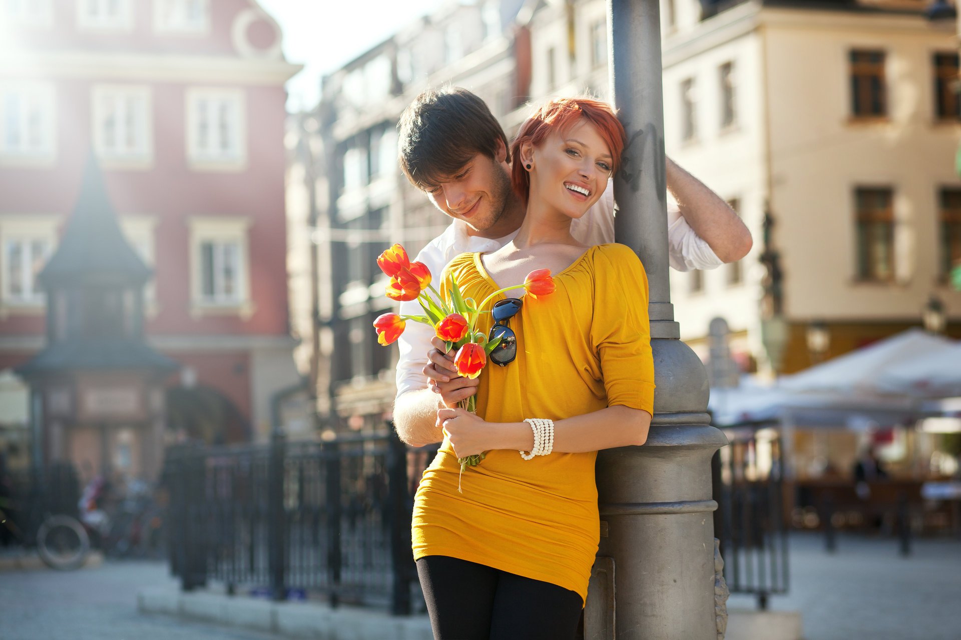 paar mädchen rotschopf kerl lachen lächeln blumen tulpen stadt zaun berühren sonnenbrille fahrrad