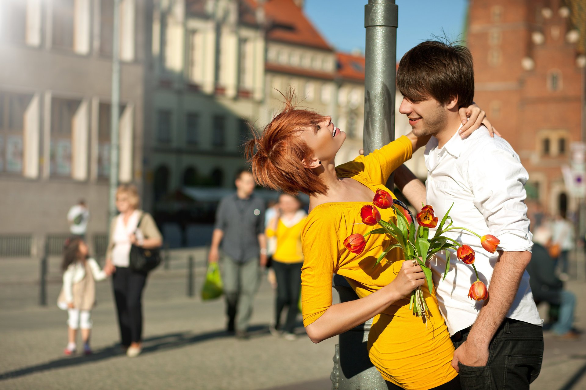 couple garçon fille rousse robe sourires pilier ville gens fleurs bouquet tulipes positif