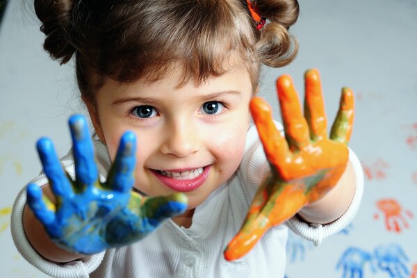 Pequeña chica shkodnaya con asas en pintura