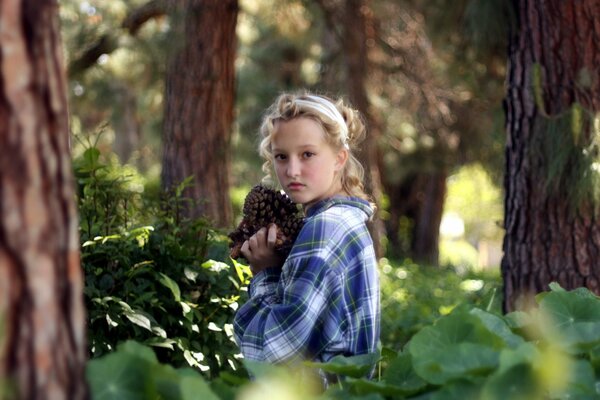 Girl in a plaid shirt in trees, blurring