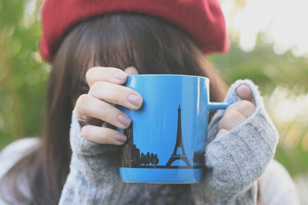 La ragazza si nasconde dietro la tazza blu