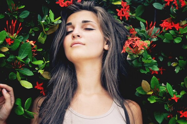 Morena chica se encuentra en un fondo verde con flores