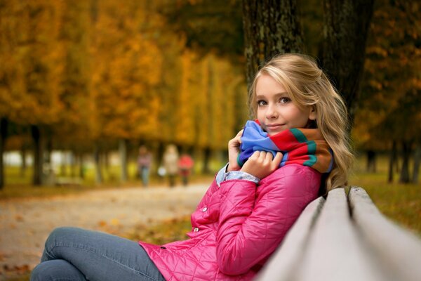 Mädchen auf einer Bank mit Herbststimmung