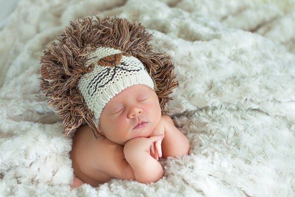 Bébé endormi dans un bonnet de Lion