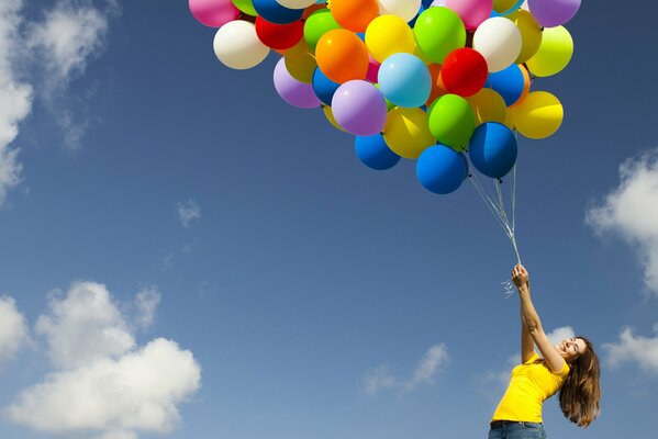 Chica sostiene un montón de bolas de colores