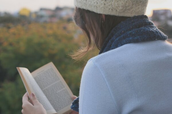 Ragazza bruna legge un libro nel parco