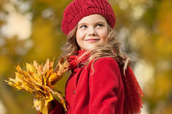 A girl in red clothes and yellow leaves