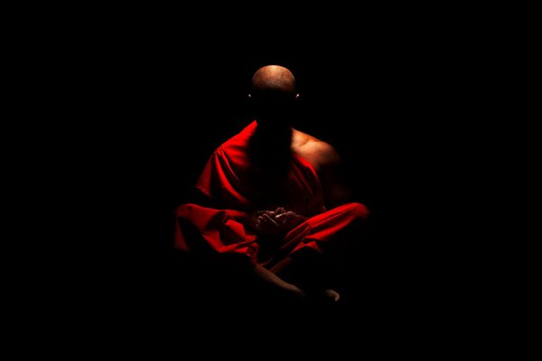 A Buddhist monk meditating in the dark