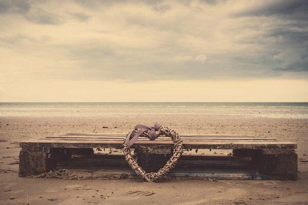 Cuore dimenticato su una panchina in riva al mare