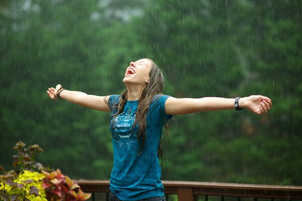 A young girl rejoices in the rain