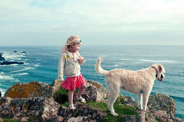 Niña con perro en la playa