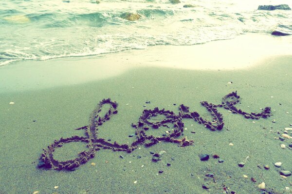 Inscription Love sur le sable mouillé, bord de mer, plage