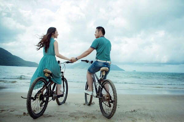 Amantes en bicicleta en la playa