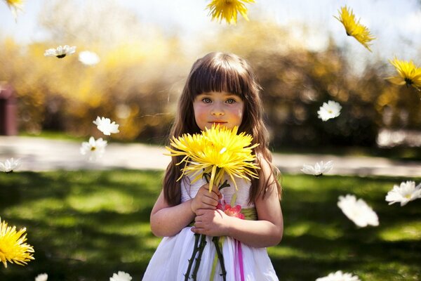 A girl with a bouquet of yellow asters