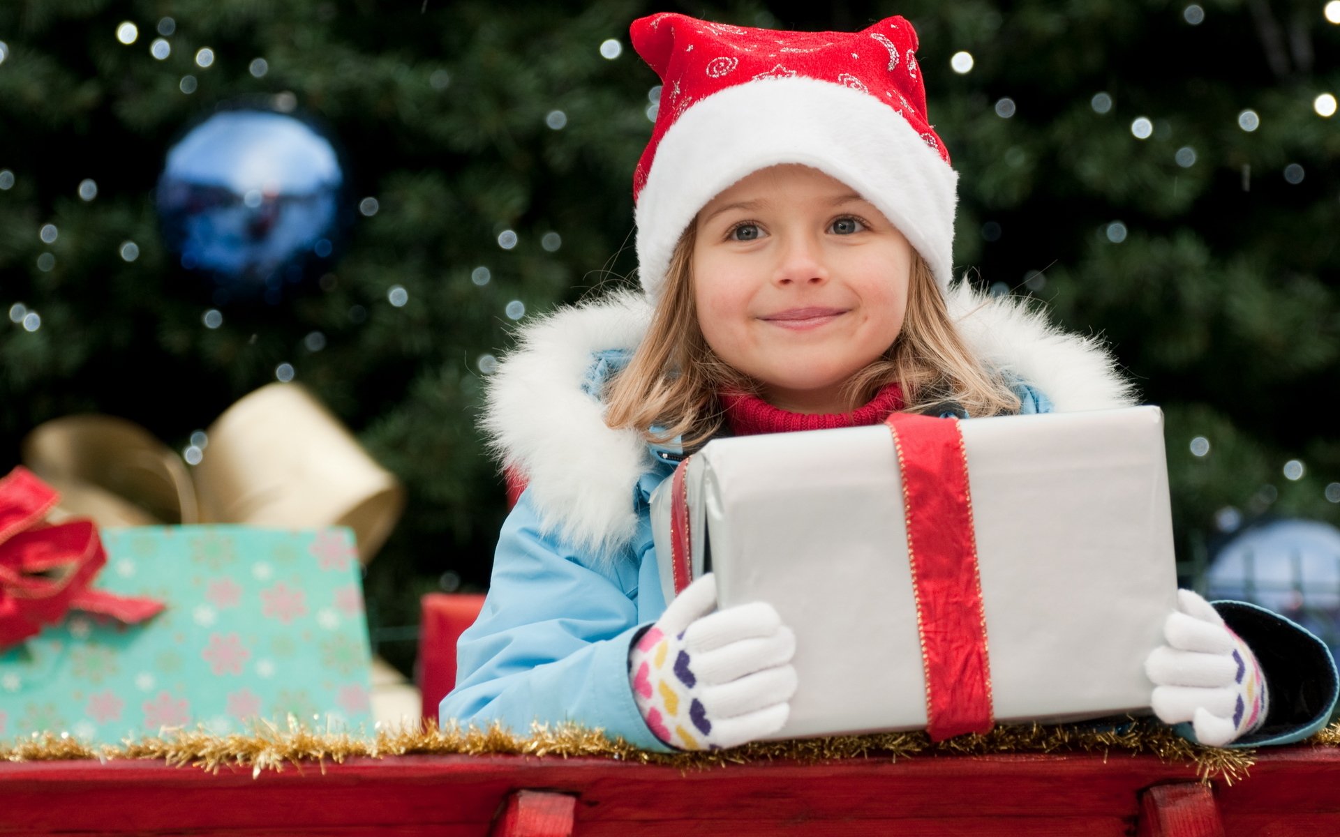 año nuevo vacaciones vacaciones niño niña sonrisa felicidad alegría deleite regalo caja oro cinta arco azul chaqueta gorro guantes