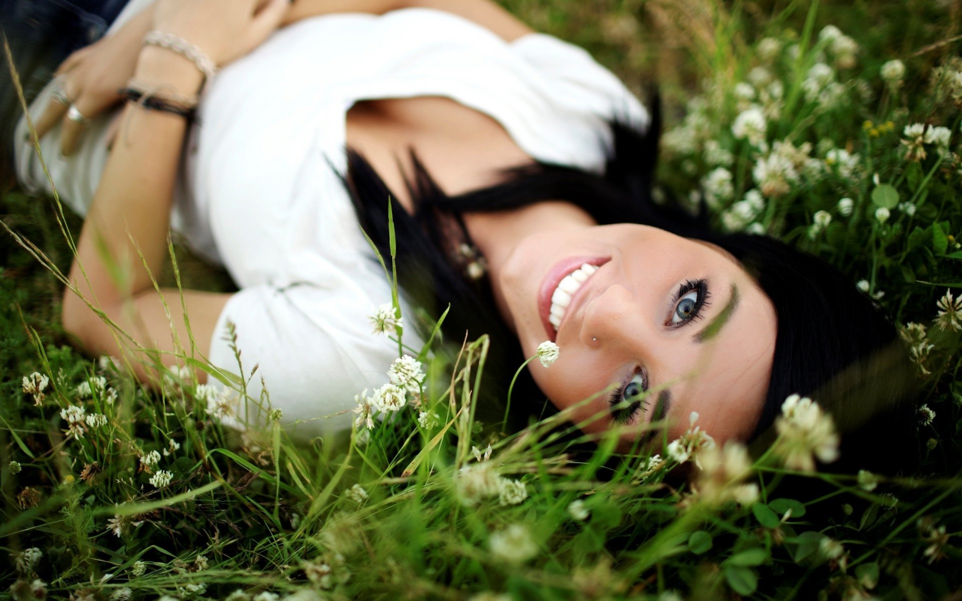 mädchen braunhaarig natur grün gras blumen gesicht lächeln blick