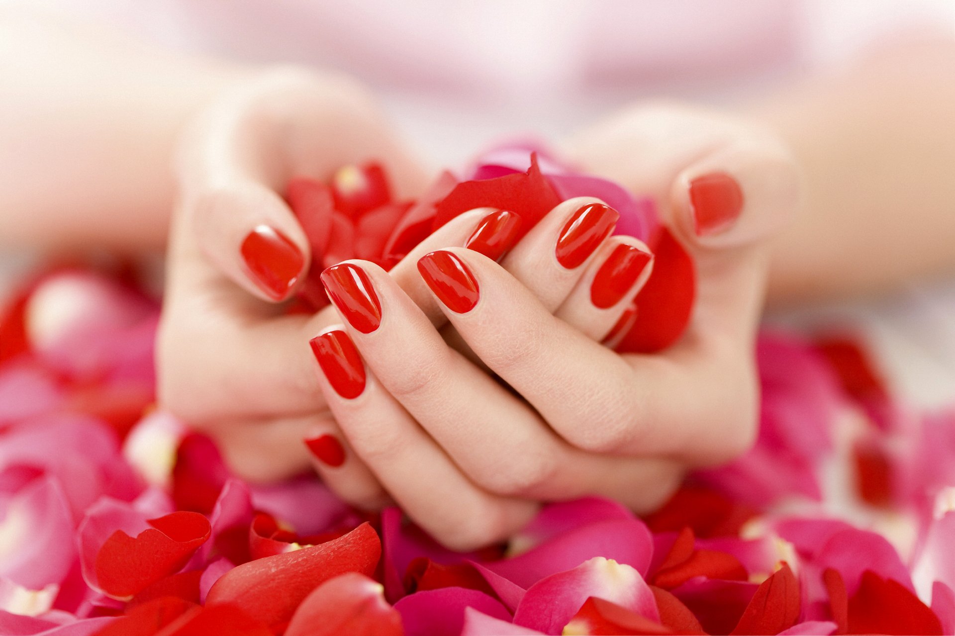 manos manicura esmalte de uñas rojo pétalos suavemente