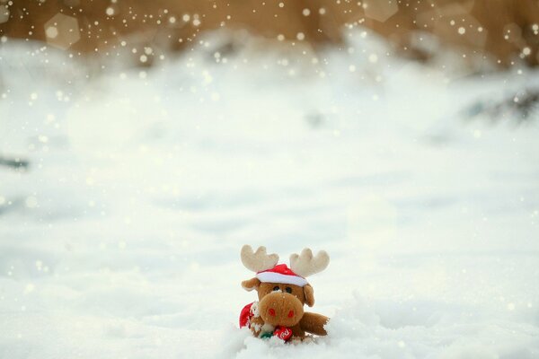 Cervo giocattolo in un cappello nella neve