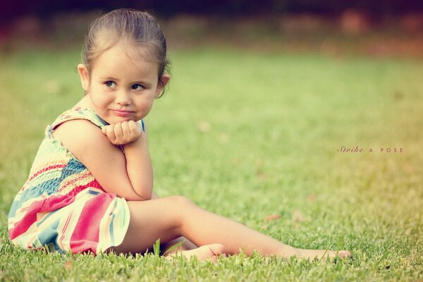 The little girl was thinking while sitting in a clearing