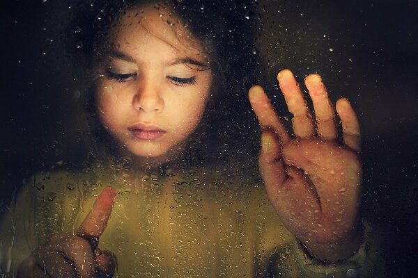 Girl catches drops on glass