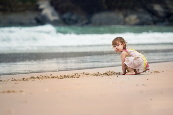 A girl on the beach. Playing with sand