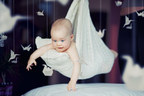 Schönes Baby lächelt glücklich im Kissen liegend