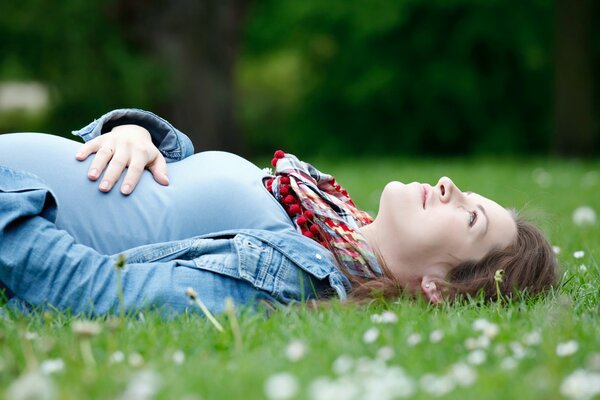 Fille enceinte sur l herbe verte