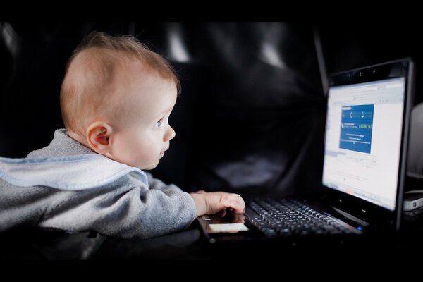 Niño pequeño delante de la computadora portátil