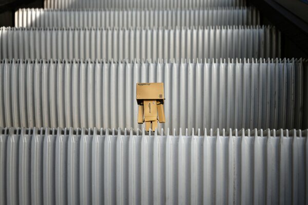 Pequeña Caja en los escalones de la escalera mecánica