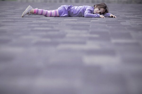 The girl is lying on the street