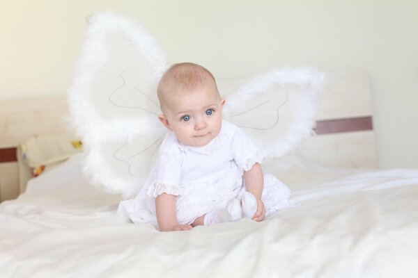 Fille avec des ailes d ange sur le lit