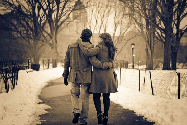 Pareja en el parque en el camino de las linternas de invierno