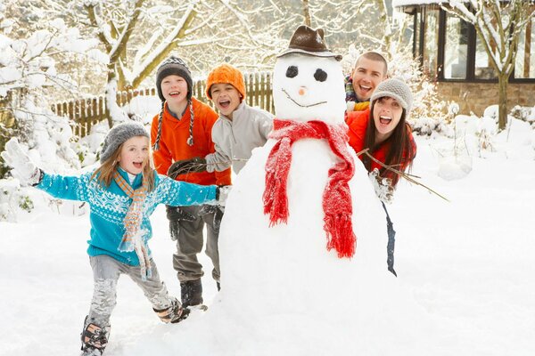 Winter lustiges Familienfoto beim Schneemann