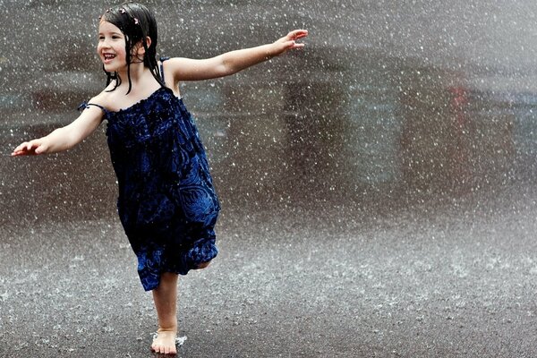 Chica con vestido azul bajo la lluvia