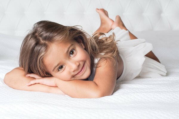 A radiant child on a luxurious bed