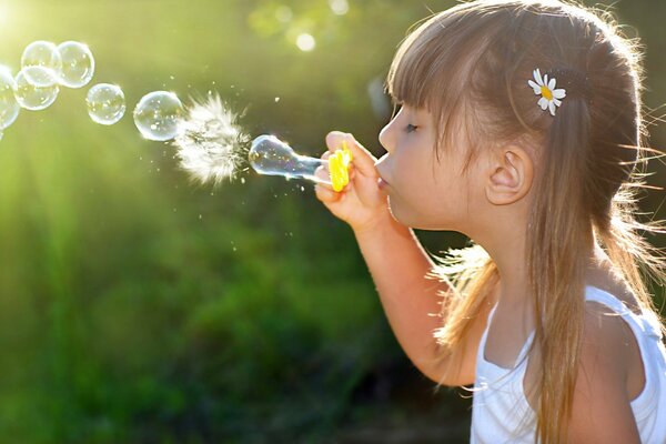 A girl blows soap bubbles