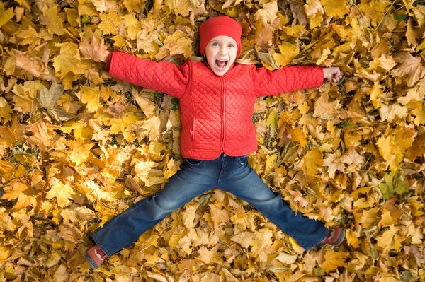 Niña nadando en el follaje de otoño