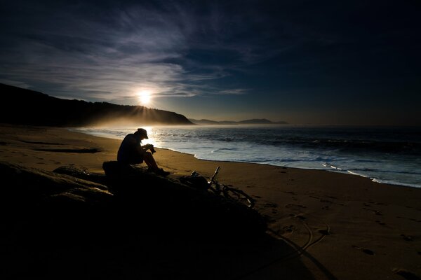 Fotógrafo en el fondo del amanecer del mar