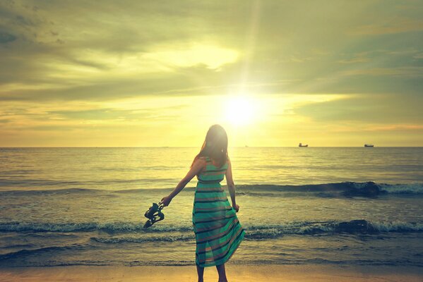 The girl admires the sea wave and the sky