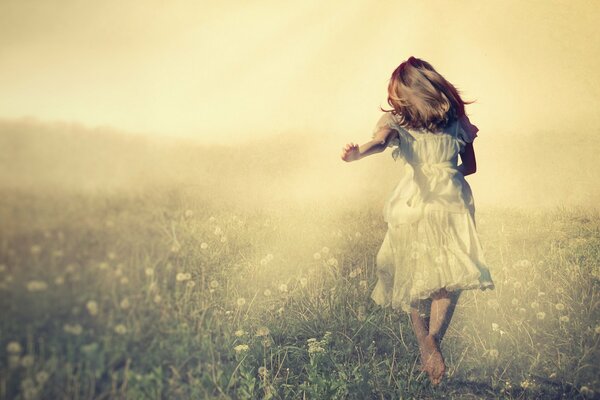 Ragazza in abito bianco che corre attraverso il campo