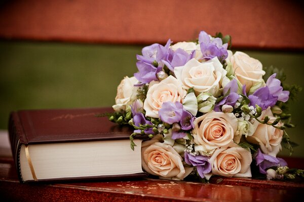 A book and a beautiful bouquet on the bench