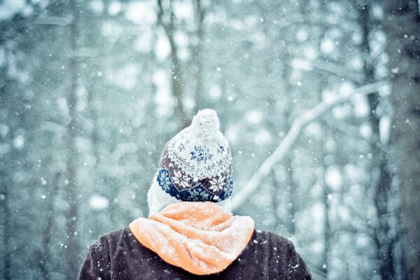 Uomo in cappello nella foresta invernale