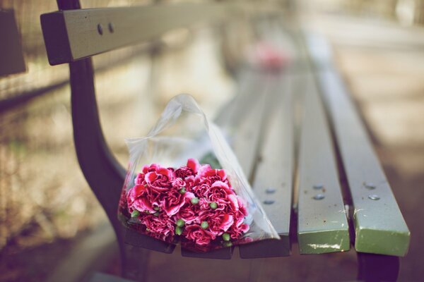 Un ramo de flores descansa en un banco