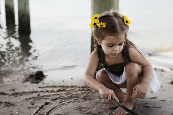 Ragazza con i fiori nei capelli sulla spiaggia