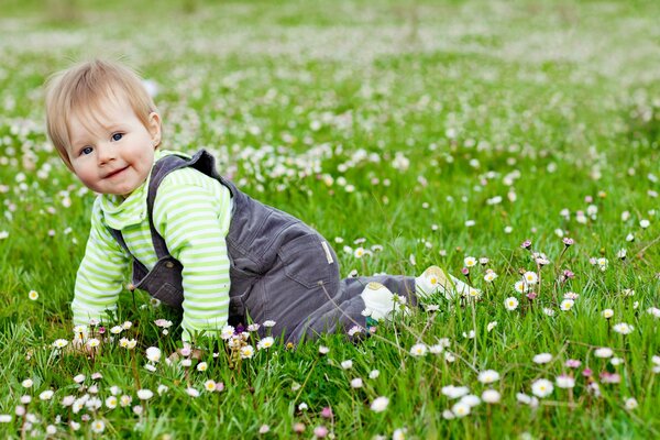 Heureux enfant assis dans l herbe avec des fleurs